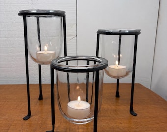Juego de 3 portavelas modernos de cristal con soportes/plantas de metal negro.