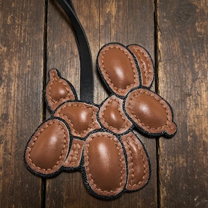 Handmade leather dog backpack accessories and personalized dog keychains are unique gifts for dog lovers.