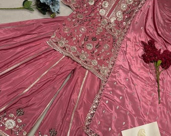 May include: A dusty rose sharara set featuring a tunic with intricate silver embroidery and mirror work, paired with wide-leg trousers and a matching dupatta. A small card with the text streeAndstyle and a paisley logo is included.
