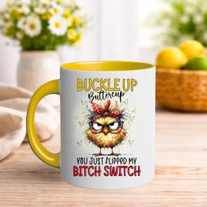 May include: White ceramic mug with a yellow interior and handle. The mug features a cartoon chick with glasses and a red bandana, and the text "BUCKLE UP Buttercup YOU JUST FLIPPED MY BITCH SWITCH".