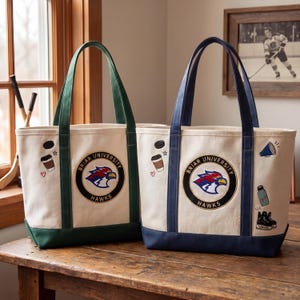May include: Two canvas tote bags with the "Briar University Hawks" logo. One bag has green handles and trim, the other has navy blue. Both have additional embroidered patches of a coffee cup, hockey puck, and other sports-related icons.