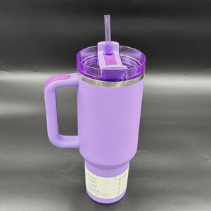 Peut inclure: Un gobelet isotherme lavande avec une poign&eacute;e et un couvercle transparent. Le gobelet a un bord en acier inoxydable et une poign&eacute;e lavande assortie. Une paille transparente est ins&eacute;r&eacute;e dans le couvercle. Id&eacute;al pour les boissons chaudes ou froides.