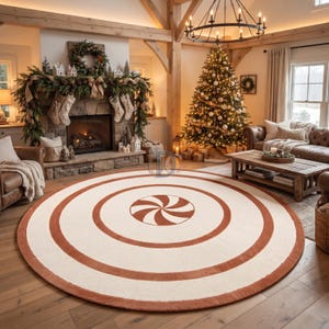 Puede incluir: Una alfombra redonda grande con una base de color crema, decorada con anillos concéntricos de color naranja quemado y un patrón de espiral central que recuerda a un caramelo de menta. La alfombra tiene una textura tejida plana sobre un suelo de madera.