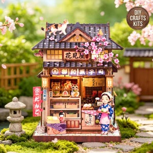 May include: A miniature wooden Japanese sweet shop model kit featuring a dark tiled roof, a calico cat on top, and cherry blossom branches. The interior displays shelves of sweets, a small figure in a blue kimono, and signs with Japanese text.