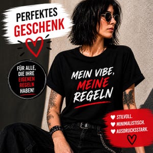 Könnte beinhalten: Schwarzes T-Shirt mit dem Text "MEIN VIBE, MEINE REGELN" in Weiß und Rot. Das Shirt hat auch den Text "PERFEKTES GESCHENK" und andere deutsche Texte. Die Person trägt eine Sonnenbrille.