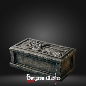 May include: A rectangular, gray stone box with a detailed relief carving on the lid. The carving depicts a figure in robes holding a staff. The box has a weathered appearance, suggesting age. The text "Dungeon Master Shop" is visible.