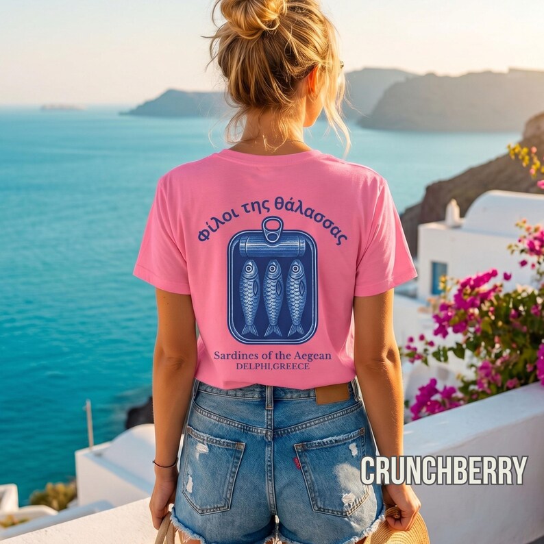 Vintage sardine can shirt featuring classic Mediterranean seafood artwork and retro coastal typography on the back of a white Comfort Colors 1717 tee. The detailed blue fish illustration creates a nostalgic European summer vibe perfect for seaside outfits, Greek travel fashion, beach aesthetic wardrobes, foodie gift ideas, nautical inspired streetwear, and relaxed everyday coastal style.