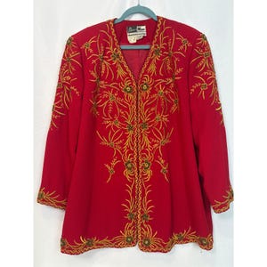 May include: A long-sleeved red blazer featuring intricate gold thread embroidery and small bead accents in a floral pattern. The garment has a V-neckline and a front opening. A label inside the collar reads Ben Marc International.