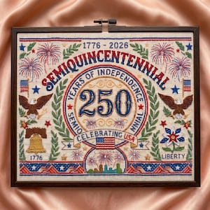 May include: A framed cross-stitch celebrating the Semiquincentennial, 250 years of American independence. The design features eagles, fireworks, the Liberty Bell, and the American flag, with the years 1776-2026.