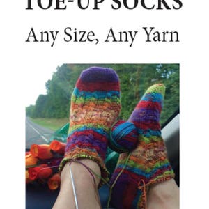 May include: A pair of colorful toe-up socks, knitted in a striped pattern with a ball of yarn. The socks are being worked on with knitting needles. The image text reads "CUSTOM FIT TOE-UP SOCKS Any Size, Any Yarn Linda Schmidt June 2017".