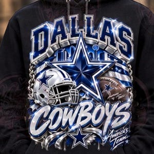 Può includere: Una felpa nera con cappuccio caratterizzata da una grande stampa grafica del logo dei Dallas Cowboys, un casco da football, un pallone e la scritta Dallas Cowboys e America's Team in tonalità blu metallizzato e argento con un motivo a stella.