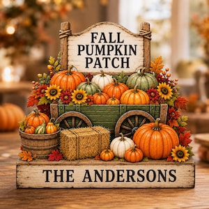 Puede incluir: Un letrero decorativo de madera con un carro verde lleno de calabazas naranjas, blancas y verdes, girasoles y hojas de otoño. El letrero superior dice FALL PUMPKIN PATCH y la base tiene la inscripción THE ANDERSONS.