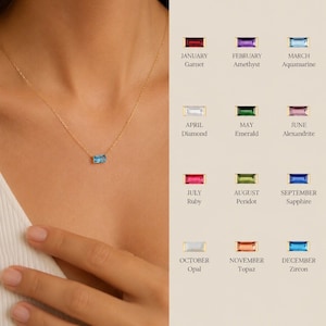 Puede incluir: Un collar de cadena dorada con un colgante de piedra preciosa azul rectangular de corte baguette. Al lado, una tabla muestra doce piedras de nacimiento etiquetadas por mes: enero granate, febrero amatista, marzo aguamarina, abril diamante, mayo esmeralda, junio alejandrita, julio rubí, agosto peridoto, septiembre zafiro, octubre ópalo, noviembre topacio y diciembre circón.