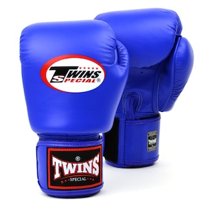 Può includere: Un paio di guanti da boxe blu brillante con il logo Twins Special in un ovale rosso sul davanti e una toppa rettangolare nera e rossa sul cinturino da polso. I guanti presentano una finitura liscia e un sistema di chiusura a strappo.