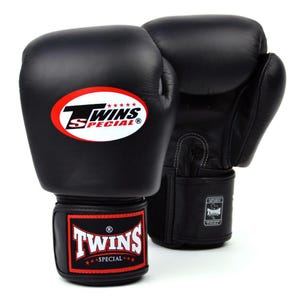 Puede incluir: Un par de guantes de boxeo de cuero negro. Los guantes tienen un logotipo blanco y rojo que dice "TWINS SPECIAL". Las correas de muñeca también muestran el logotipo "TWINS SPECIAL". Diseñados para el entrenamiento de boxeo y artes marciales.