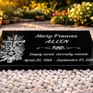 May include: A black granite memorial plaque with the name "Mary Frances Allen" and dates "April 20, 1966 - September 27, 2023" engraved in white. A cross and floral design are on the left. The text "Deeply loved, eternally missed" is also included.