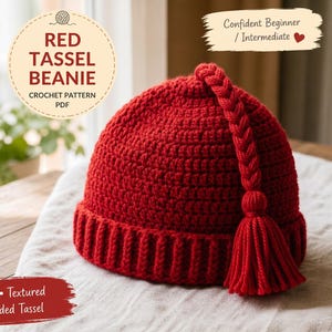 May include: A red crocheted beanie with a braided tassel and a ribbed brim. The hat is made from a textured yarn and is displayed on a white cloth. Text on the image reads "Red Tassel Beanie" and "Crochet Pattern PDF".