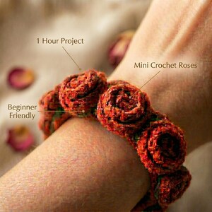 May include: A bracelet made of mini crochet roses in shades of red and orange with green accents. The image includes text labels that read 1 Hour Project, Mini Crochet Roses, and Beginner Friendly, pointing to the crocheted floral design.