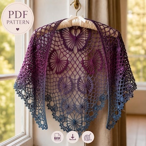 Puede incluir: Un chal de ganchillo hecho a mano en un degradado de tonos morados y azules, exhibido en una percha. El chal presenta un diseño de mariposas y flores, con un delicado patrón calado. El texto "PDF PATTERN" es visible en la esquina superior izquierda.