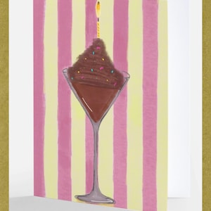 May include: Greeting card featuring a chocolate dessert in a martini glass with a lit candle. The illustration has a pink and yellow striped background. The card is inside a gold frame.