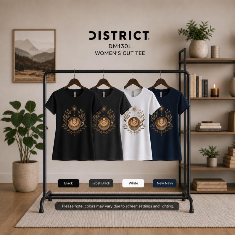 Puede incluir: Cuatro camisetas en negro, negro helado, blanco y azul marino cuelgan de una percha. Cada camiseta presenta un dise&ntilde;o de taza de caf&eacute; con un patr&oacute;n floral dorado. El texto "DISTRICT. DM130L WOMEN'S CUT TEE" es visible.