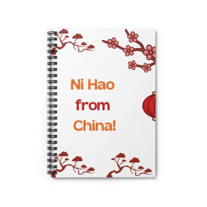 May include: Spiral-bound notebook with a white cover featuring the text "Ni Hao from China!" in orange and red. The design includes illustrations of cherry blossoms, branches, and a red lantern.
