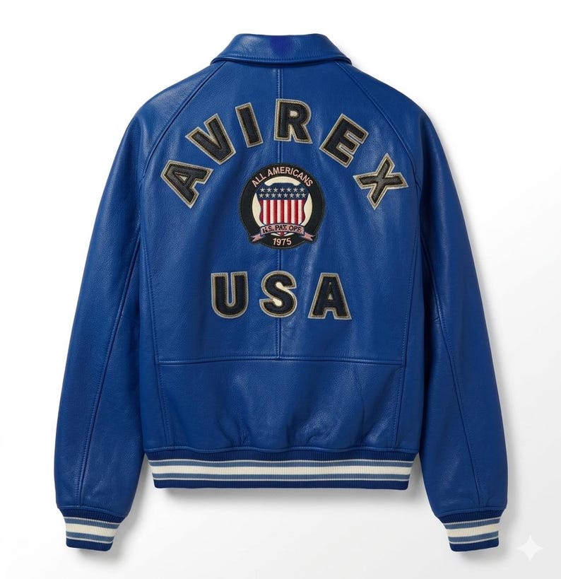 May include: A bright blue leather jacket with the word "AVIREX" across the shoulders and "USA" below. The back of the jacket features a circular patch with stars and stripes and the words "ALL AMERICANS" and "1975". The jacket has a classic bomber style with a striped hem.