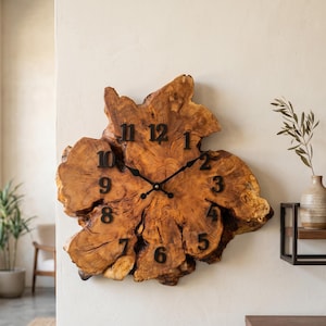Orologio da parete in legno d'ulivo con bordo naturale per un arredamento rustico.