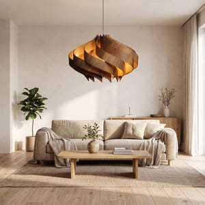 May include: A contemporary living room with a large, wooden, spiral pendant light. The light hangs above a beige sofa with cushions and a wooden coffee table. A rug and plants complete the warm, inviting space, creating a relaxing atmosphere.