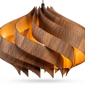May include: A wooden pendant light. The light features a distinctive design with layered, curved wooden slats in a warm brown hue, forming a spiral. The interior emits a warm glow, creating a cosy atmosphere. The light hangs from a brown cord.