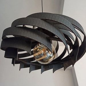 May include: A contemporary pendant light in dark brown. The light fitting has a layered, curved design with a spherical, striped glass bulb. It hangs from a thin black cord, ideal for a living or dining room.