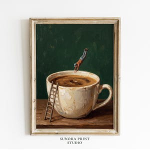 Può includere: Una stampa artistica incorniciata raffigurante una grande tazza da caffè bianca e materica, riempita di liquido scuro su una superficie in legno. Una piccola figura con camicia arancione e pantaloni grigi si tuffa nel caffè, con una scala in legno.