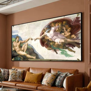 May include: A large rectangular wall art print featuring a reproduction of The Creation of Adam. The painting depicts a muscular figure reaching toward a bearded figure draped in a light pink cloth, surrounded by several smaller figures in a cloud.