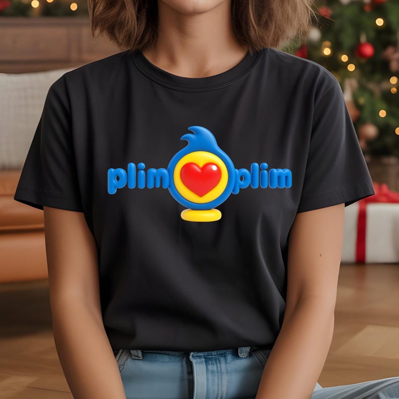K&ouml;nnte beinhalten: Schwarzes T-Shirt mit dem blauen Schriftzug "plim plim" und einer zentralen Grafik. Die Grafik enth&auml;lt eine blaue vogel&auml;hnliche Form, einen gelben Kreis und ein rotes Herz. Das T-Shirt ist aus weichem Material.