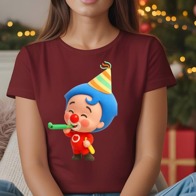 K&ouml;nnte beinhalten: Burgunderfarbenes T-Shirt mit einer Cartoon-Clown-Figur. Der Clown hat blaue Haare, eine rote Nase und eine Partyh&uuml;tchen. Er h&auml;lt ein gr&uuml;nes Party-Gadget und eine gelbe Tr&ouml;te. Das Design ist auf dem T-Shirt zentriert.