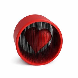 May include: A red, cylindrical art piece featuring a heart shape. The heart is formed by vertical black lines, creating a layered effect within the red outer cylinder. The design is modern and visually striking.
