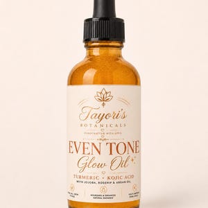May include: An amber-colored glass dropper bottle containing Even Tone Glow Oil by Tayori's Botanicals. The label features a lotus icon, text listing turmeric, kojic acid, jojoba, rosehip, and argan oil, and icons for all skin types.