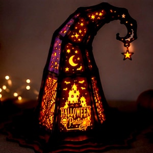 May include: A conical lamp shaped like a witch hat with a dark frame and glowing orange panels. The panels feature cutouts of a crescent moon, stars, bats, a haunted house, and spiderwebs. The text HALLOWEEN PARTY is visible, and a star charm hangs from the tip.