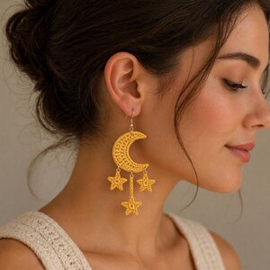 May include: Yellow crochet earrings featuring a crescent moon and three dangling stars. The earrings are handmade with a textured design, and the hook is gold-colored. The earrings are a celestial-themed accessory.