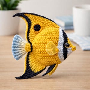 May include: A handmade crochet fish in yellow, black, white, and blue. The fish has a detailed design with fins, a tail, and a round eye. The fish is approximately 8 inches long.