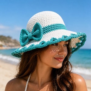 Puede incluir: Sombrero de sol de ganchillo blanco y turquesa con ala ancha y lazo turquesa. El sombrero tiene un borde festoneado y una banda turquesa alrededor de la corona. Perfecto para la playa.