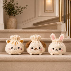 May include: Three cream-colored crochet drawstring pouches shaped like animals. The left pouch features cat ears and whiskers, the middle pouch has brown dog ears, and the right pouch has long rabbit ears with pink centers. Each has black eyes and a small mouth.