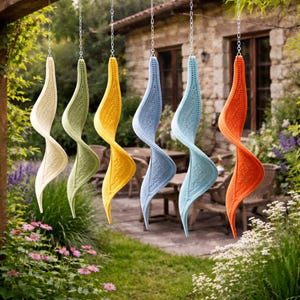 Pode incluir: Seis decorações suspensas em crochê em forma de espiral, nas cores creme, verde, amarelo, azul claro, azul e laranja. Penduradas por correntes, ideais para ambientes externos.