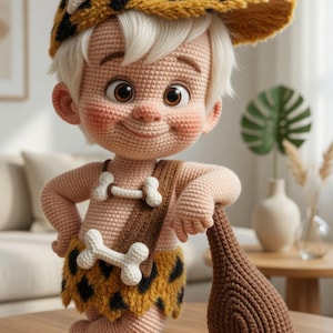 May include: A crocheted doll of a cartoon character wearing a leopard-print hat and skirt, with a bone-shaped necklace. The doll is holding a brown club and has rosy cheeks. The doll is standing on a wooden table.