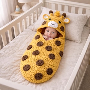 Puede incluir: Un bebé envuelto en un saco de dormir de ganchillo amarillo con temática de jirafa. El saco tiene manchas marrones y una capucha con características de jirafa. El bebé está en una cuna blanca con un colchón y una almohada blancos.