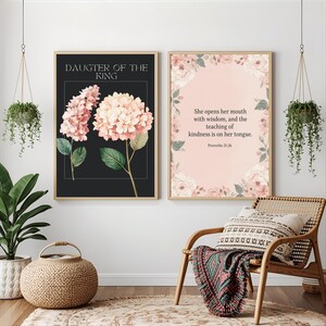 May include: Two framed floral art prints. One features pink hydrangeas on a black background with the text "DAUGTER OF THE KING." The other has a pink background with floral accents and the text "She opens her mouth with wisdom, and the teaching of kindness is on her tongue. Proverbs 31:26."