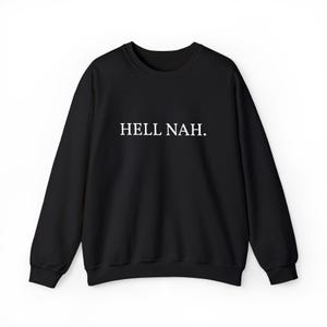 以下が含まれることがあります： 胸の中央に白いセリフ体で「HELL NAH.」というテキストがプリントされた、黒の長袖クルーネックトレーナー。襟元、袖口、裾はリブ編みになっており、すっきりとしたシンプルなデザインの衣類です。