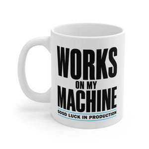 Puede incluir: Una taza de cerámica blanca con el texto negro WORKS ON MY MACHINE en una fuente sans-serif en negrita, seguido del texto azul más pequeño GOOD LUCK IN PRODUCTION subrayado con una línea azul fina en el frente.