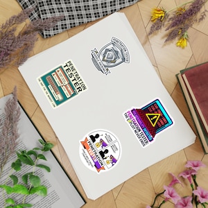 May include: A selection of vibrant stickers with cybersecurity themes. The stickers display text such as "Penetration Tester," "Vulnerability Detected," and "Google Hacking Certified." Designs include a shield, a computer screen, and a diagram. The stickers are on a white surface.