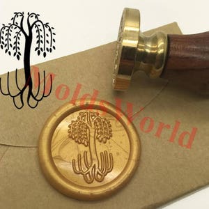 Könnte beinhalten: Ein goldfarbener Wachssiegel-Stempel mit einem Holzgriff. Der Stempel zeigt ein Design eines stilisierten Baumes mit Ästen und Wurzeln. Der Stempel wird verwendet, um ein Wachssiegel mit dem gleichen Design zu erstellen.